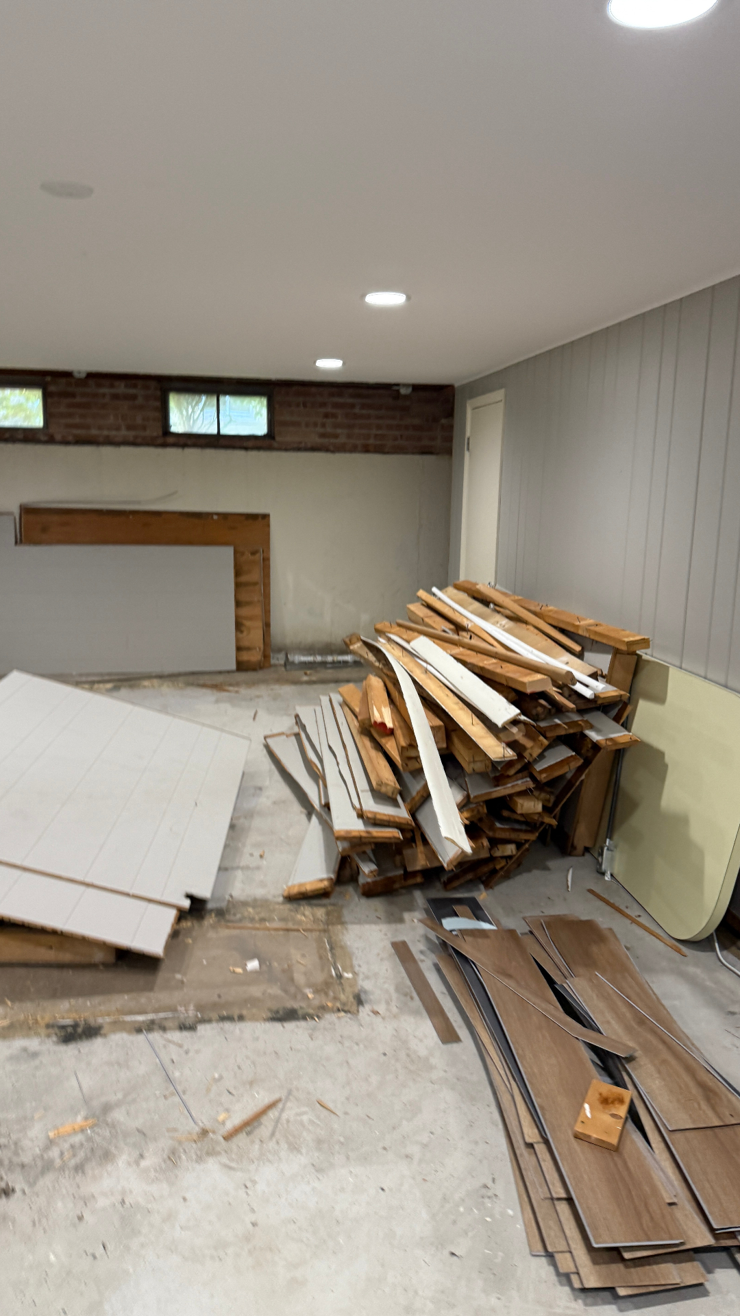 Basement debris removal Arlington Heights Illinois — stacked wood, wall material and flooring ready for haul away
