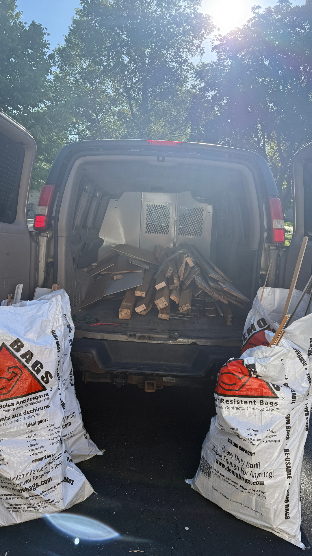 Basement cleanout haul away Arlington Heights — van loaded with flooring, wood and demo bags