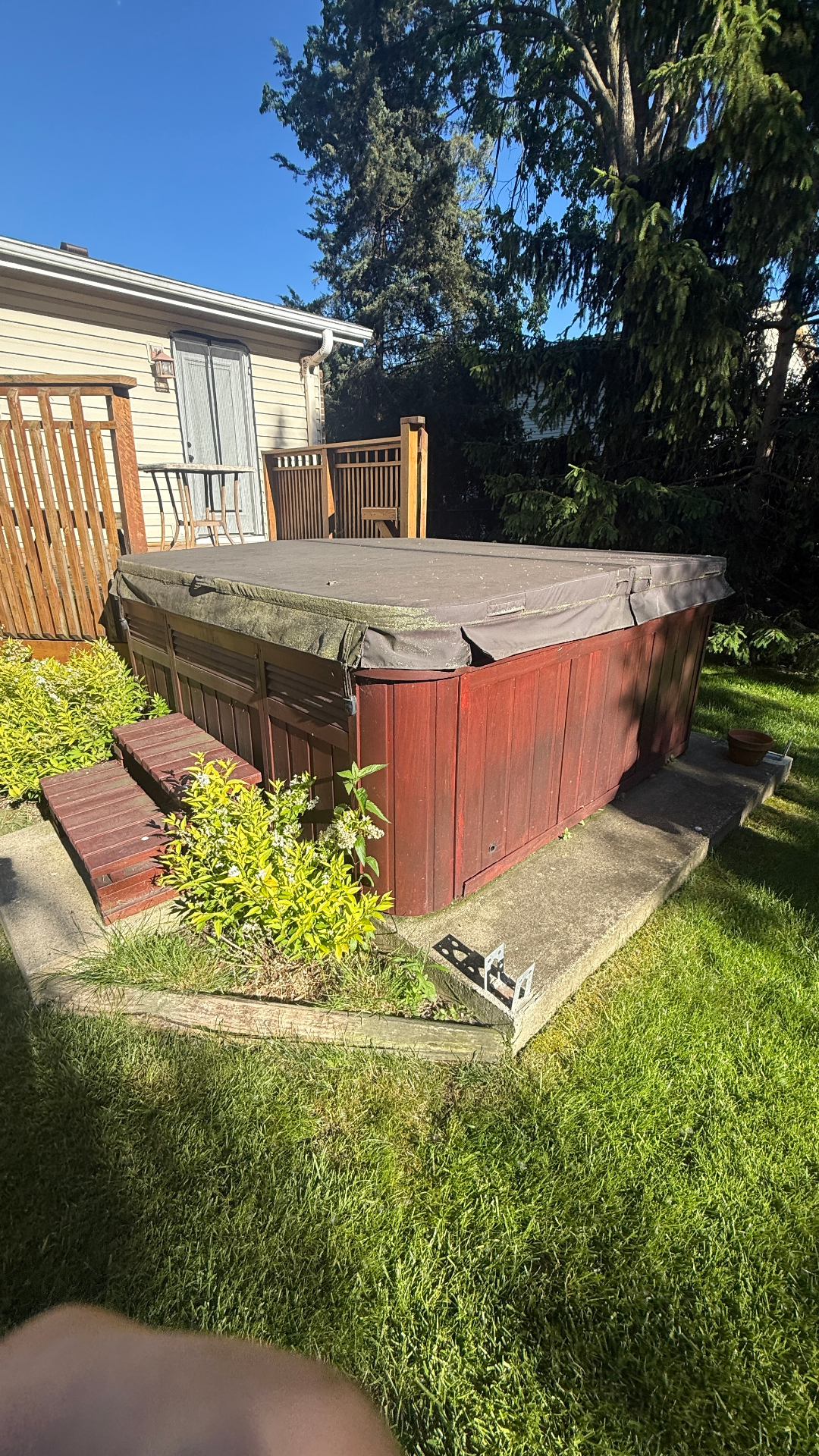 Jacuzzi removal Deerfield IL — old red hot tub in backyard before demolition and haul away