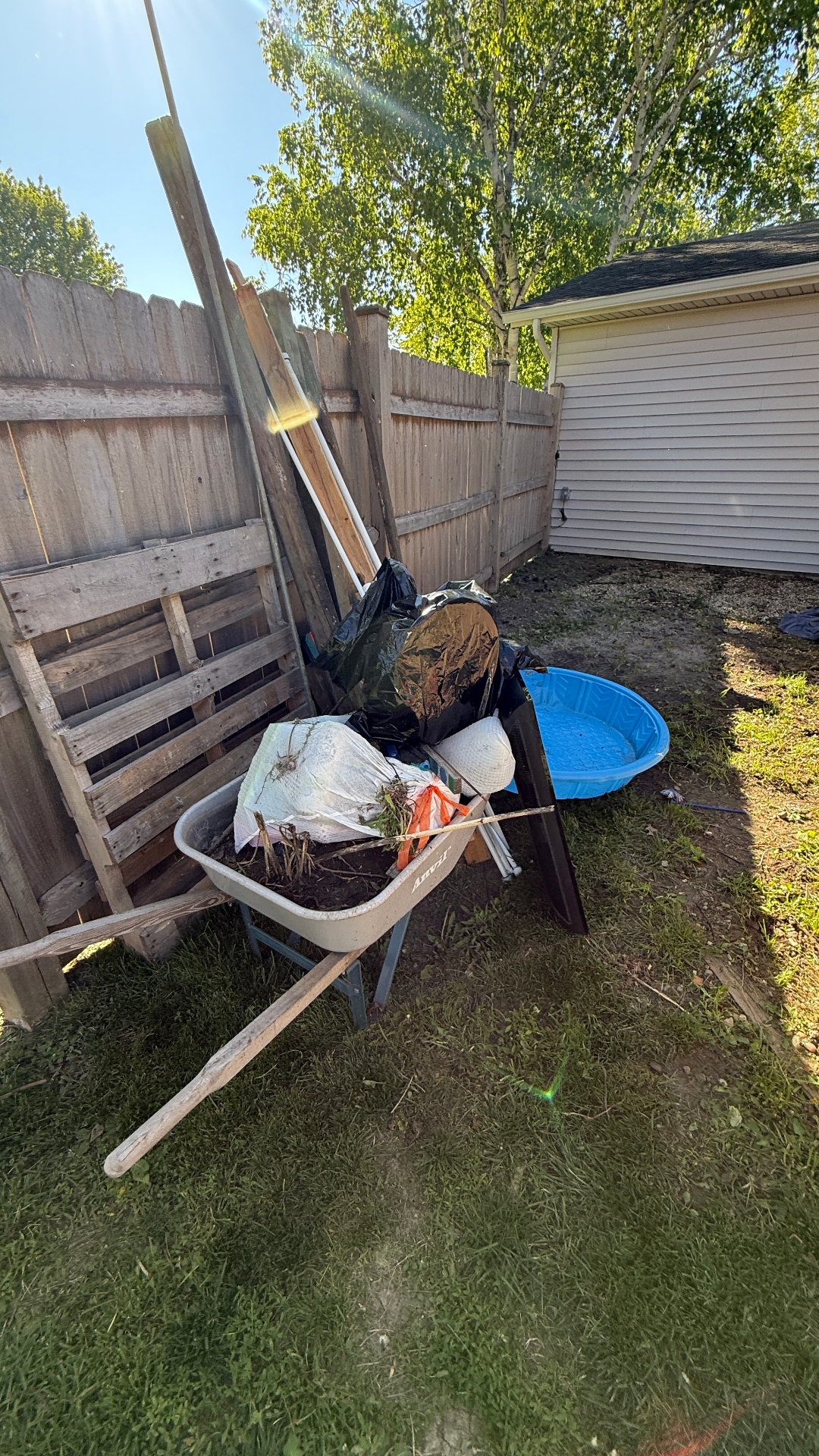 Fence line cleanup Elgin Illinois — wheelbarrow of yard debris before haul-away