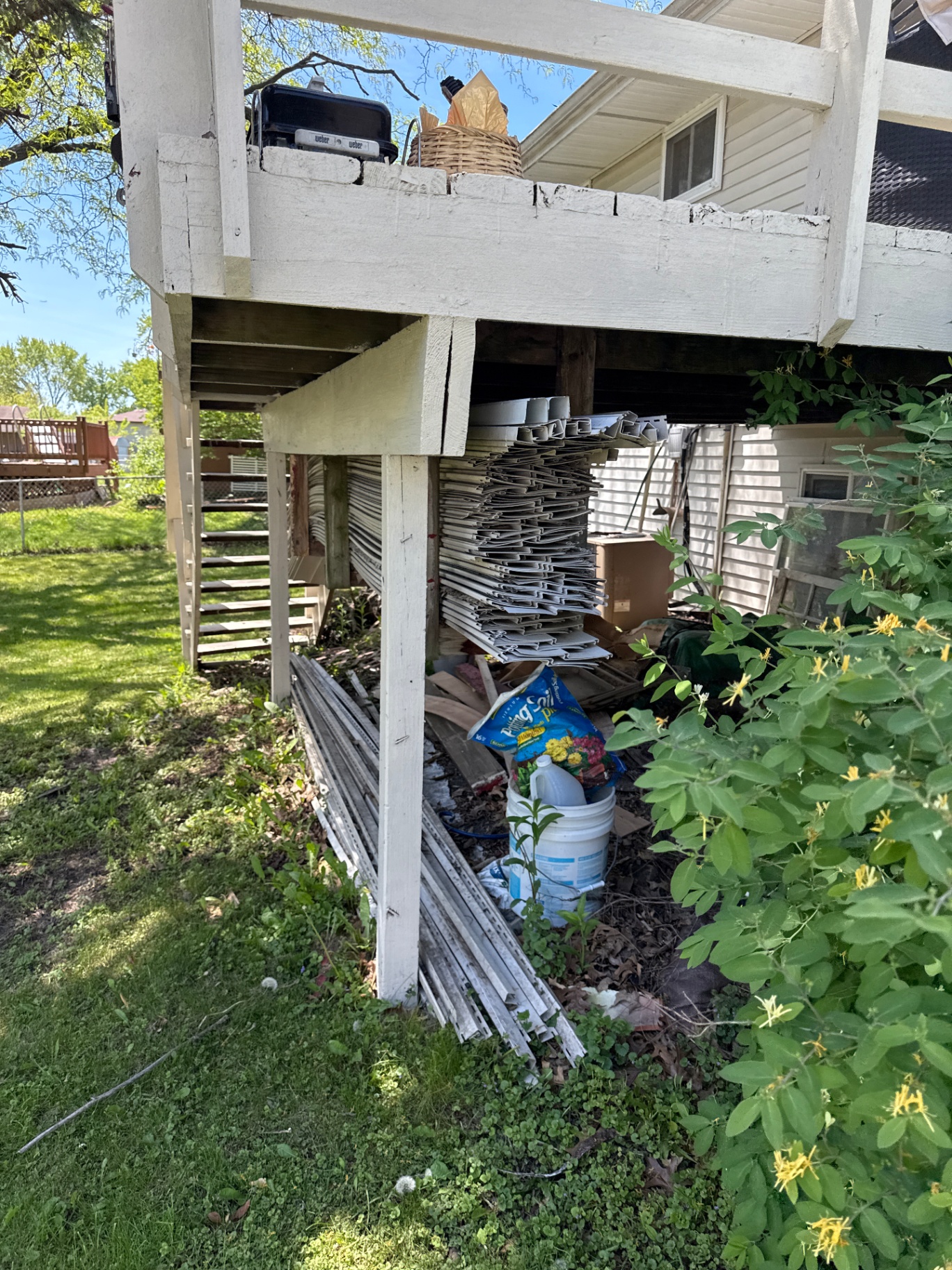 Vinyl siding haul away Hanover Park — stacked siding under deck before cleanup