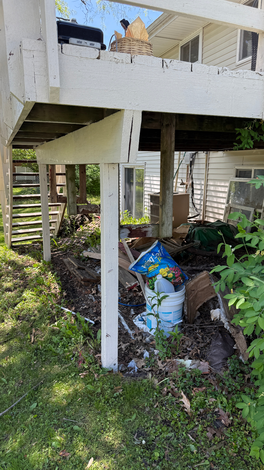 Property cleanup Hanover Park IL — debris and exterior materials under deck before haul-away