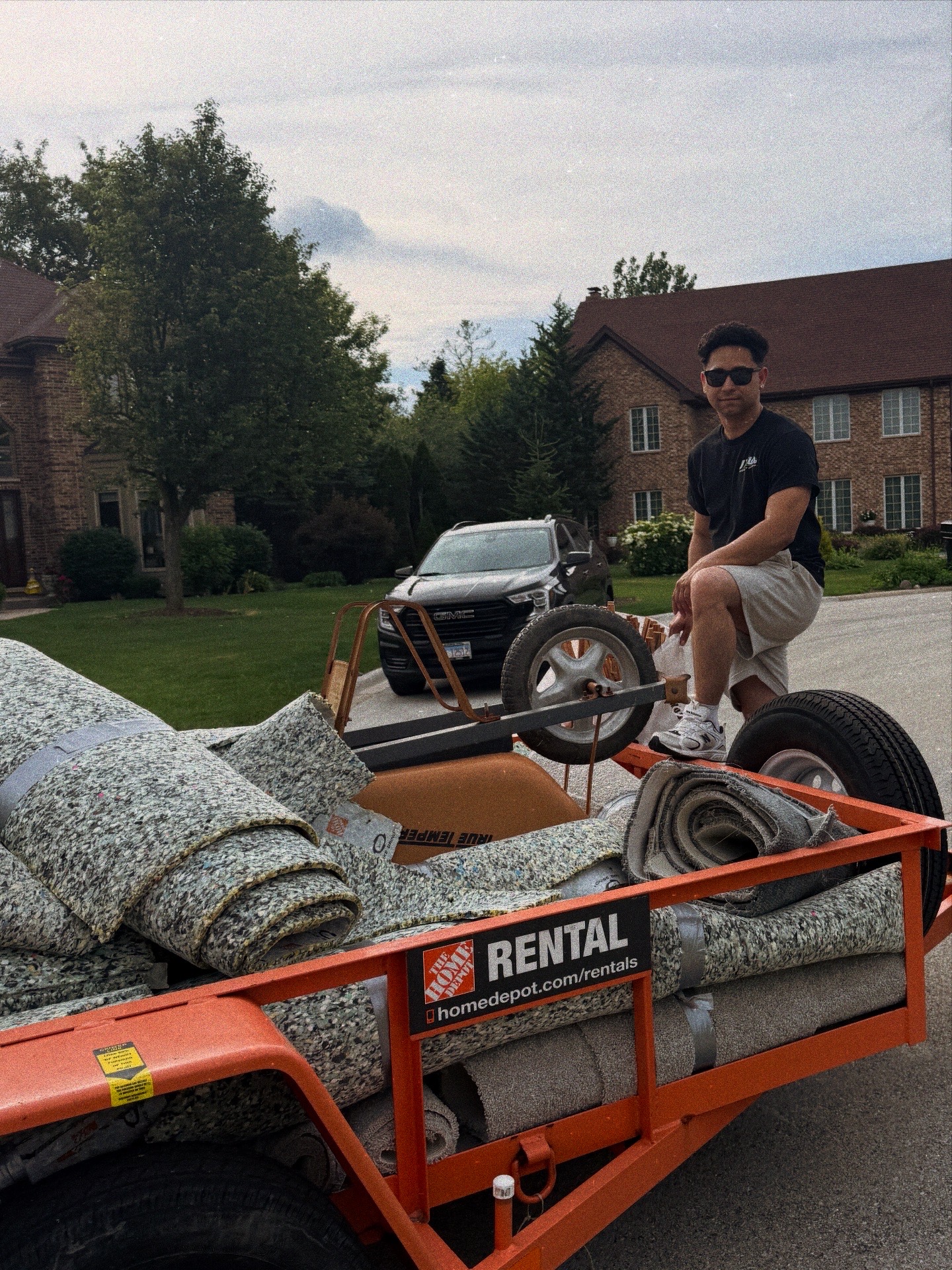 Basement carpet removal Palatine IL — JXL crew loading rolled carpet and padding onto trailer for haul away