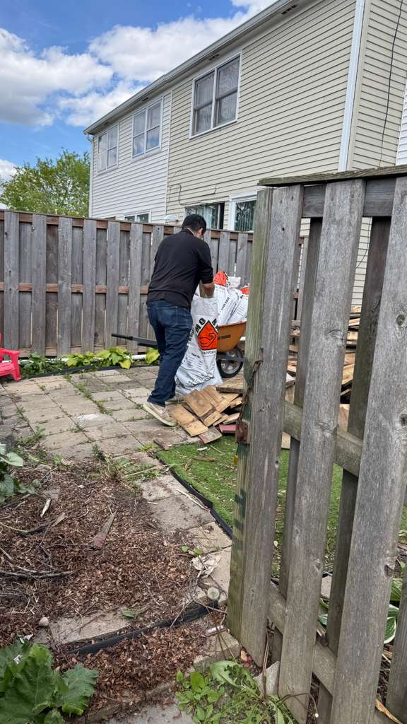 Pile of demolished patio wood and debris in Schaumburg backyard