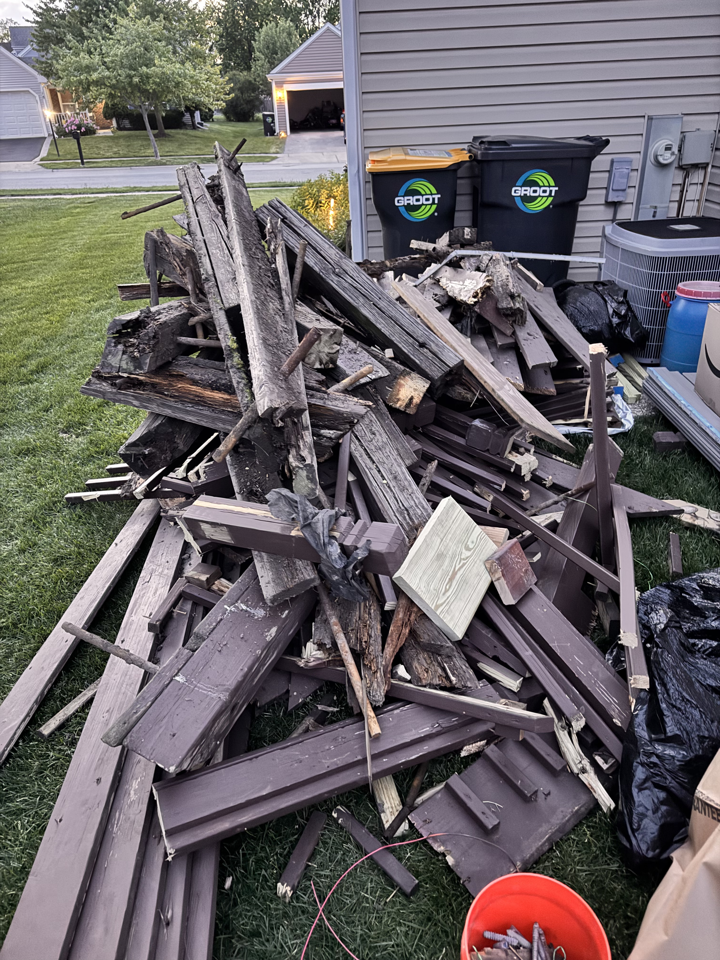 Wood deck removal Streamwood Illinois — broken patio boards and demo bags on jobsite